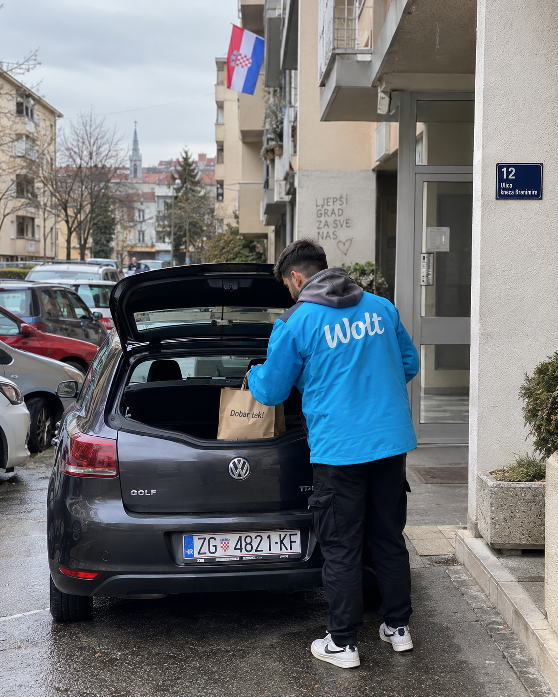 Wolt dostavljač s automobilom tijekom dostave